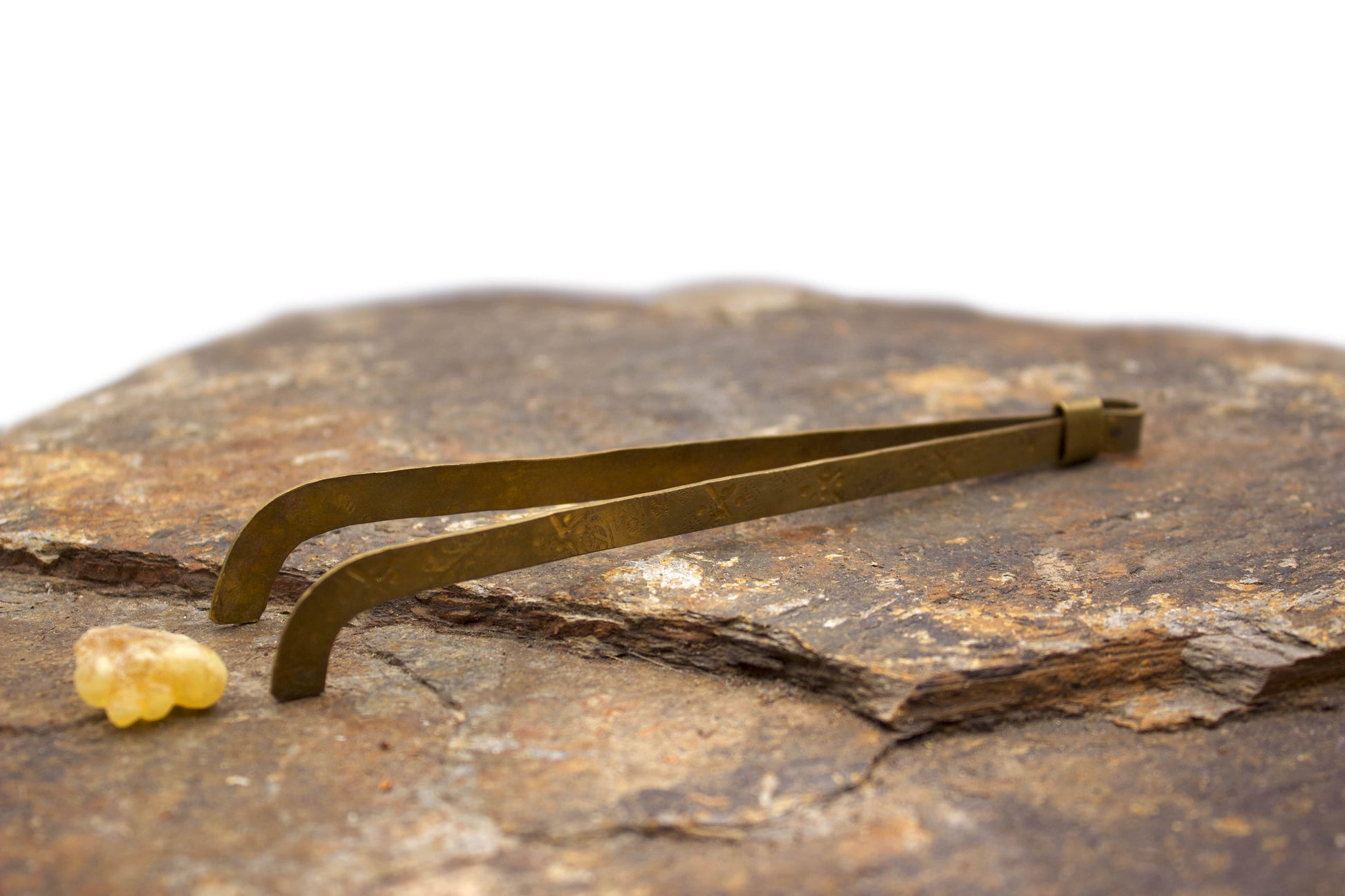 Brass tongs on a piece of stone